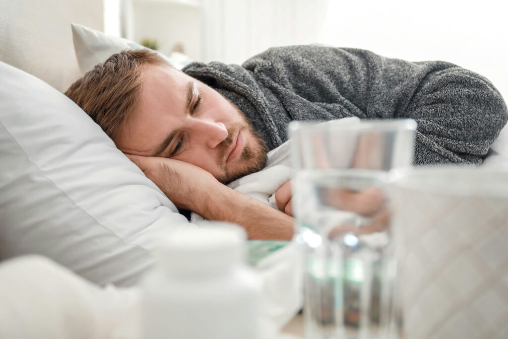 a man lying on the bed, reflecting on binge drinking vs. alcoholism